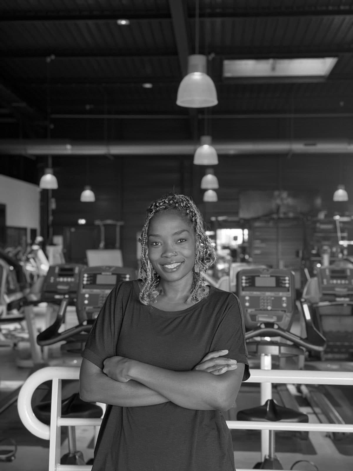 Suzanne, bras croisés, dans sa salle de sport.