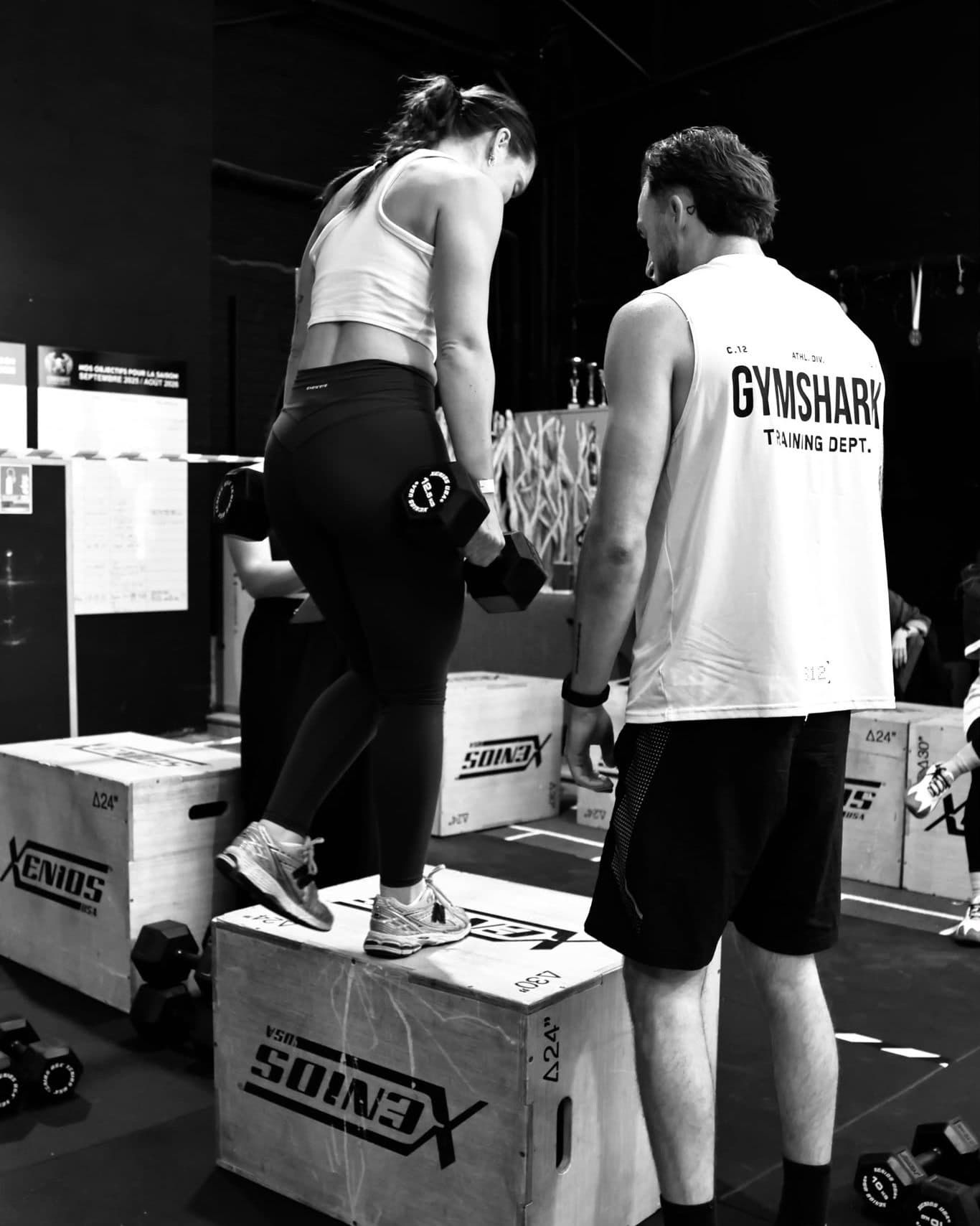 Un coach corrige la position d'une coachée sur une montée de caisson.